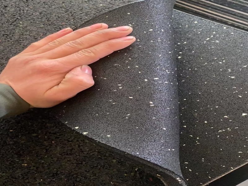 Un calibro che misura lo spessore di un tappetino da palestra in gomma da 19 mm.